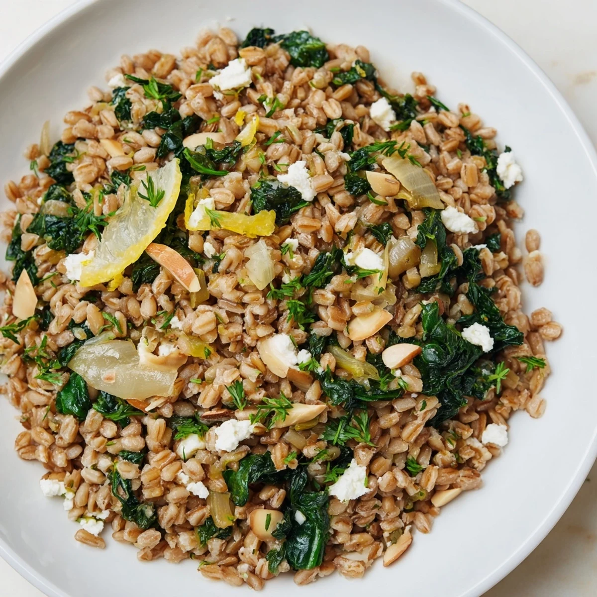 Golden-brown toasted almonds scattered over a delicious Farro & Greens Pilaf with fresh greens.