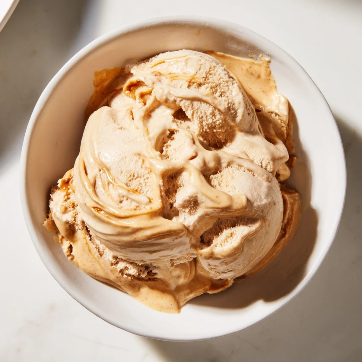 A scoop of rich peanut butter banana ice cream, swirled and ready to enjoy as a cool treat.