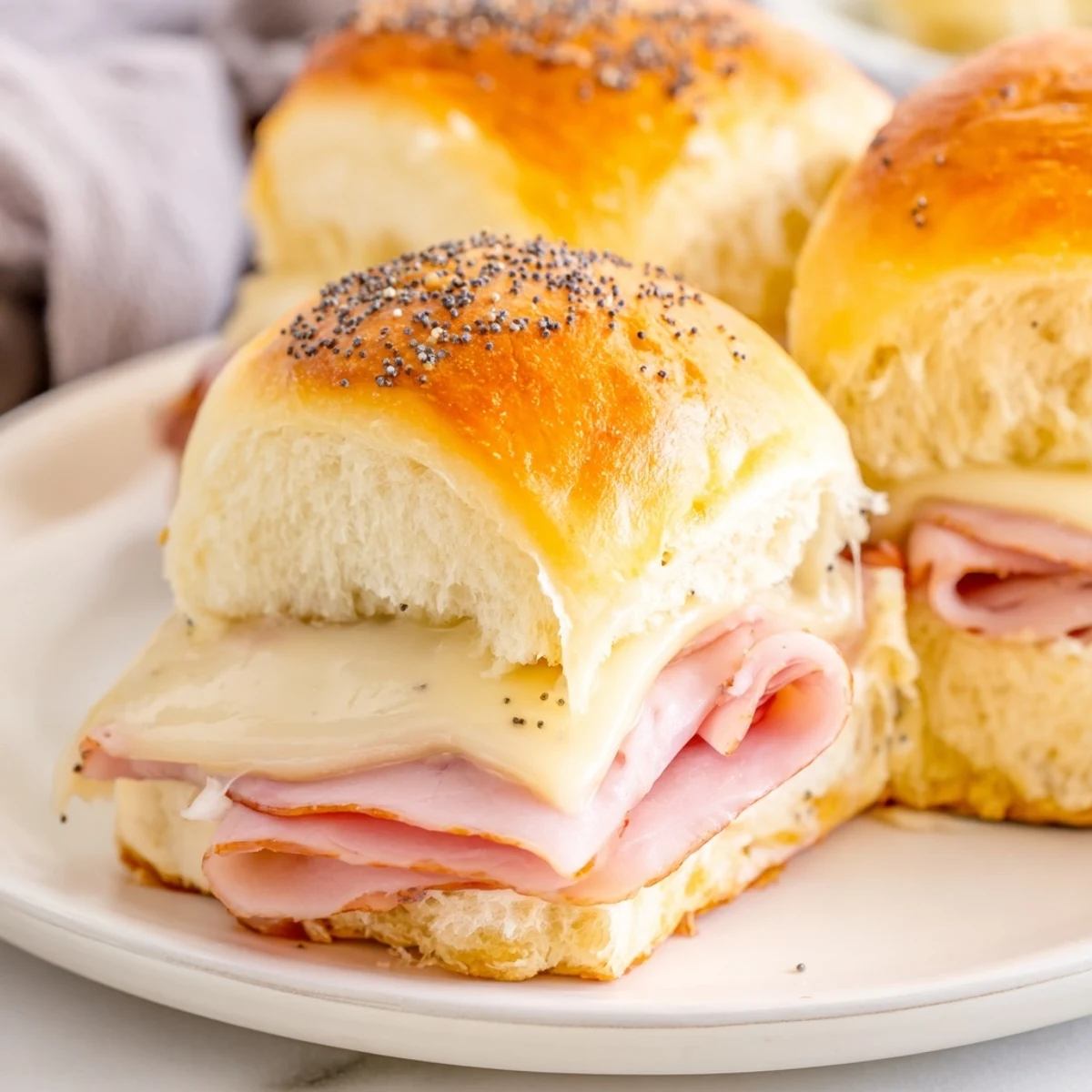 Warm, golden Baked Ham and Cheese Party Sliders with melted cheese and a buttery glaze.