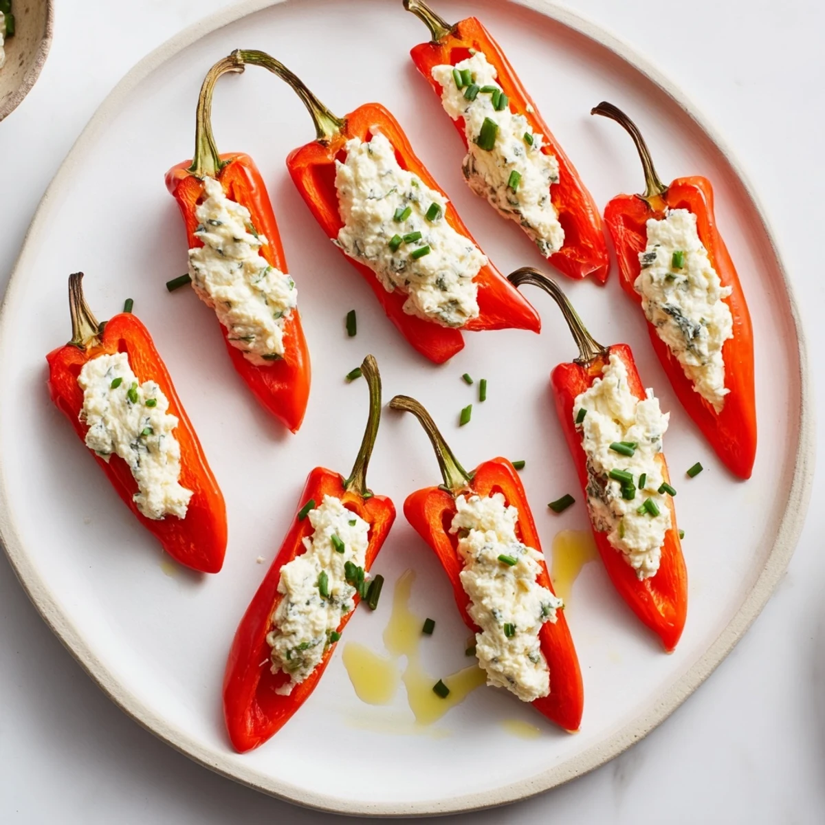 Freshly-drizzled olive oil glistens on colorful mini bell pepper halves stuffed with feta cheese.