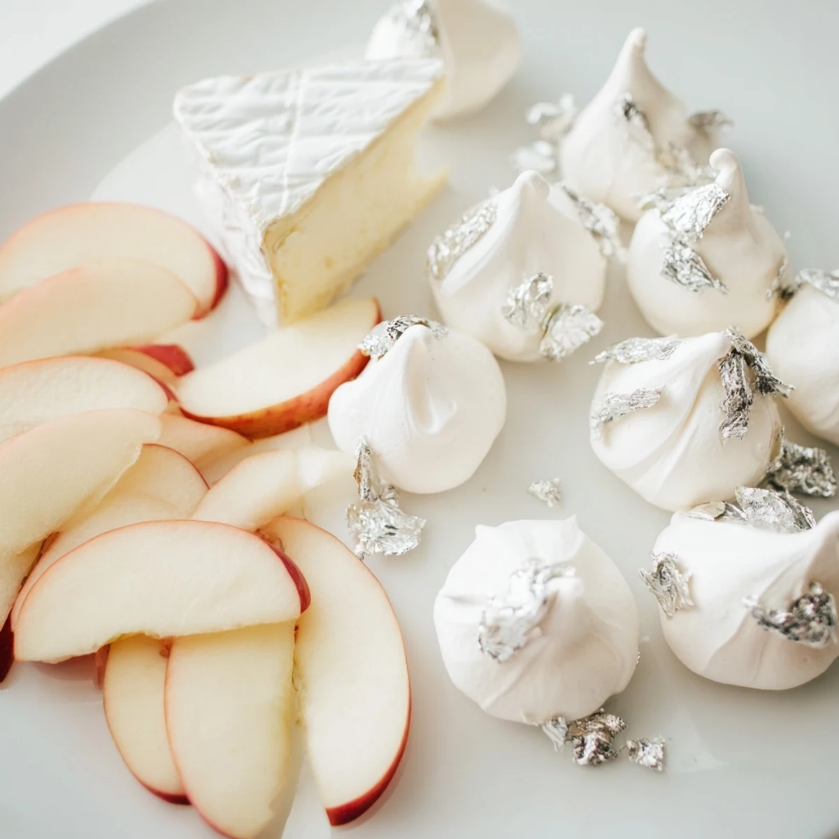 Pearly Gates cheese board features creamy brie, sliced peaches, and delicate meringue kisses.
