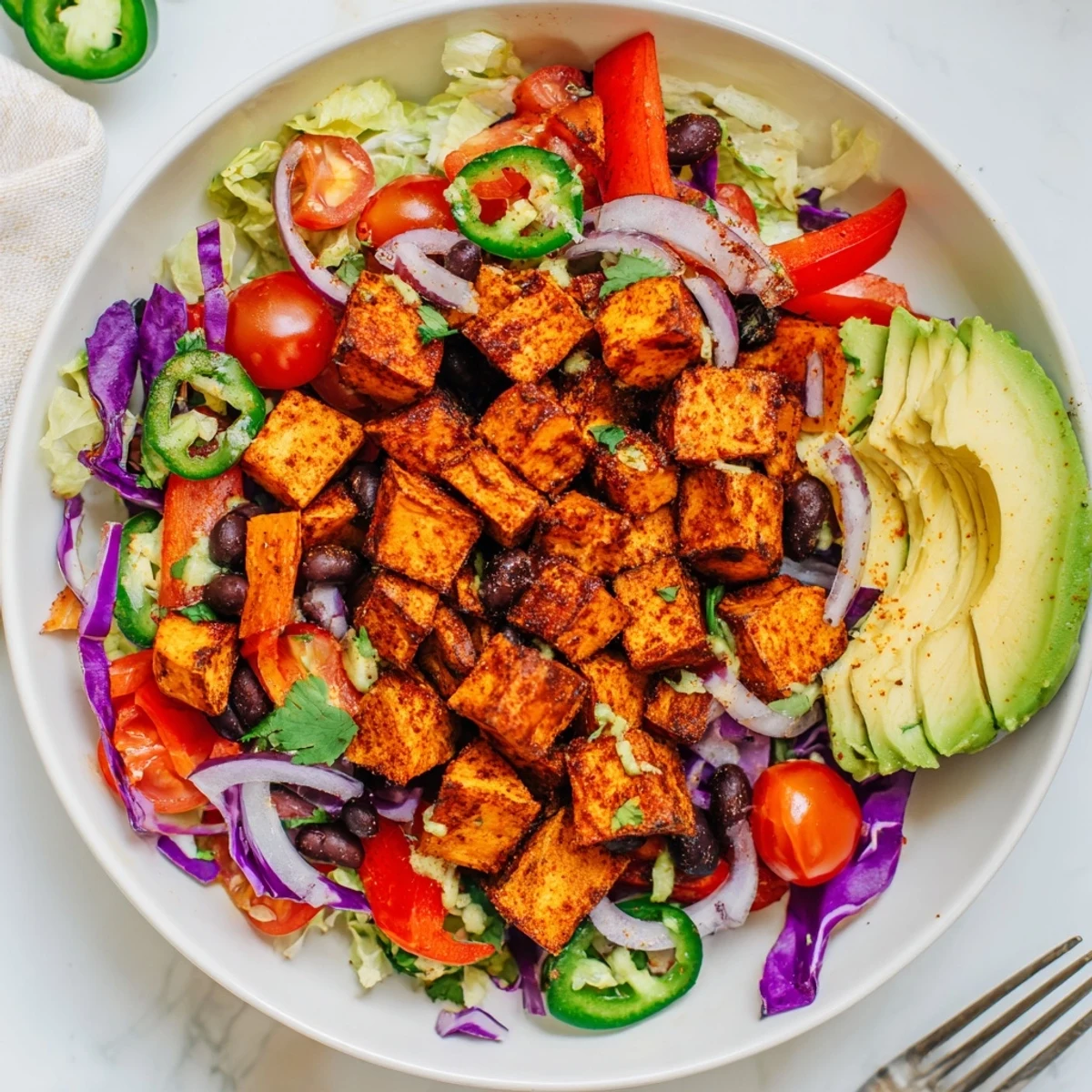 Roasted sweet potato taco bowls, a colorful vegan meal bursting with fresh vegetables and zesty dressing.