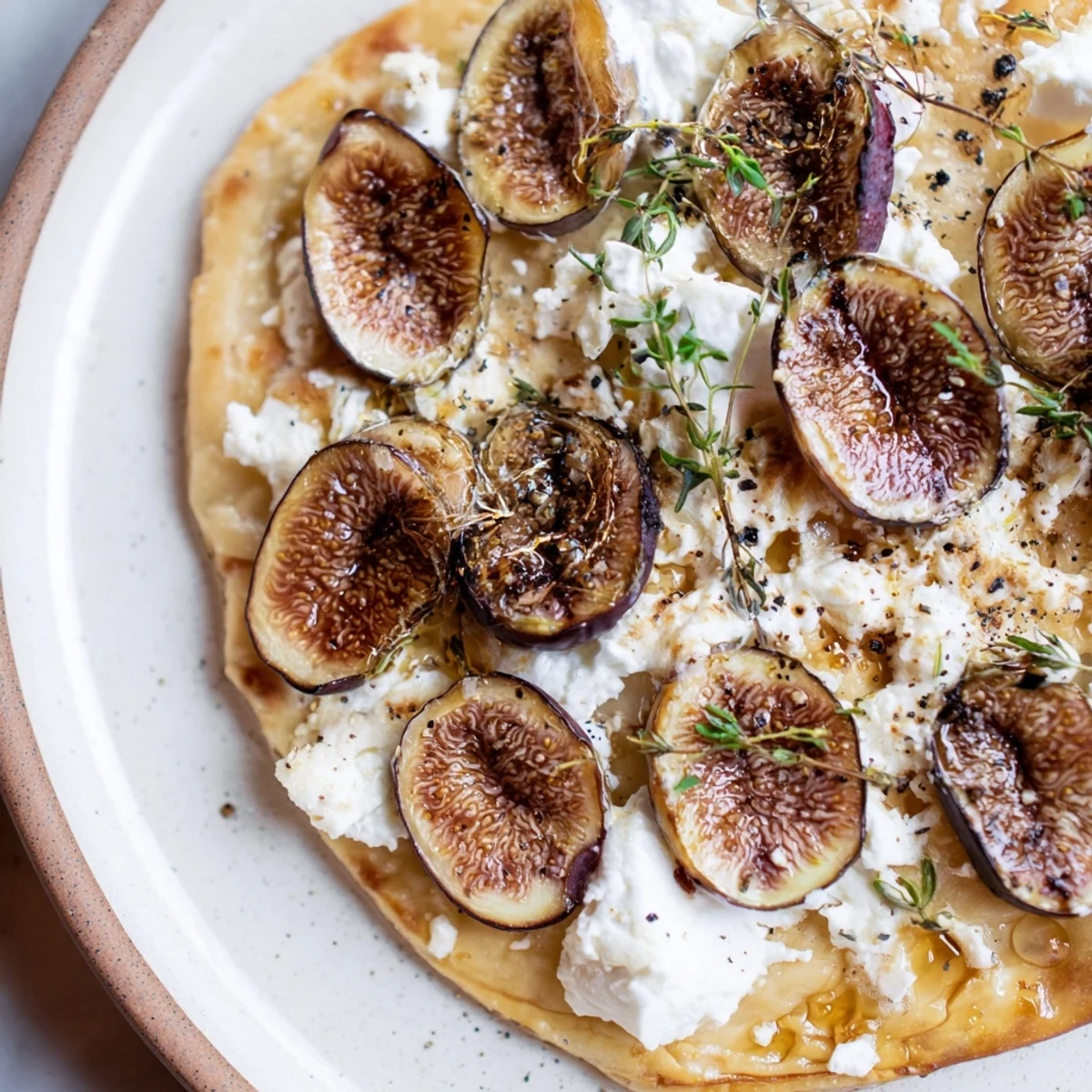 A delectable puff pastry truffle pizza, featuring figs and goat cheese, drizzled in honey before serving.