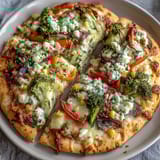 Festive St. Patrick's Day rainbow veggie flatbread pizza with colorful bell peppers, broccoli, and cherry tomatoes.  