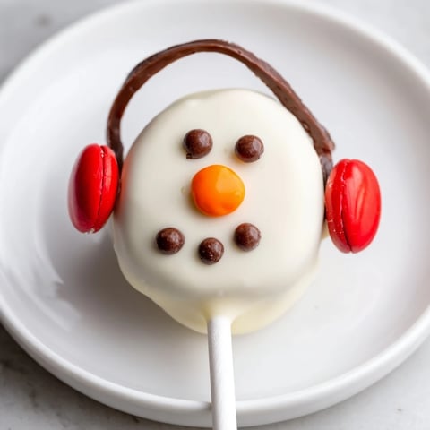 Budget-Friendly Oreo Snowman Pops: adorable chocolate-covered snowmen with cute candy eyes, a fun, easy dessert.