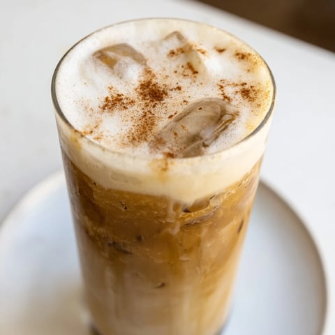 Frothy Iced Brown Sugar Oat Latte, a creamy vegan coffee drink over ice, ready to sip.