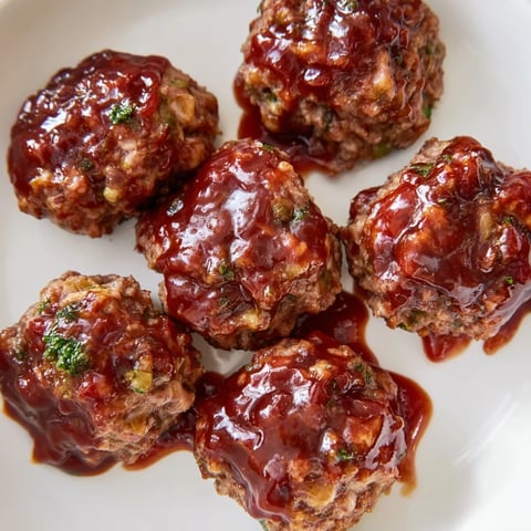 Golden-brown mini meatloaf bites, glistening with maple-mustard glaze, ready to serve with family.
