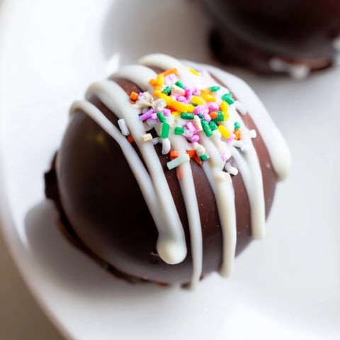 A close-up of homemade hot chocolate bombs dusted with cocoa powder, ready for serving.