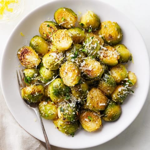Oven-roasted Brussels sprouts with Parmesan, crispy topping perfect for festive dinners.  