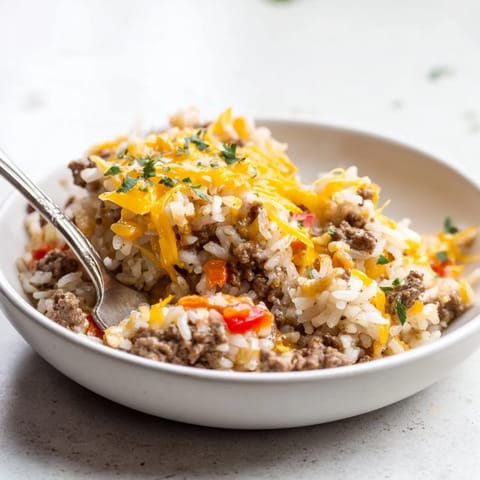 Comforting One-Pot Cheesy Beef and Rice garnished with fresh parsley on the table.  