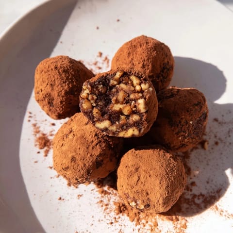 These sweet Date & Walnut Truffles, dusted with cocoa powder, looks perfectly round and enticing.