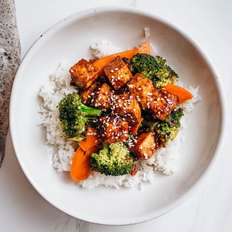 A close-up image shows steaming Sesame Tofu & Broccoli, ready to be served over rice.