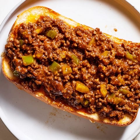 A close-up of delicious, juicy Sloppy Joes piled high on warm hamburger buns, ready to eat.
