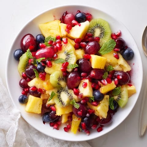 Colorful Three Kings Royal Fruit Platter overflowing with grapes and a drizzle of honey-lime dressing.