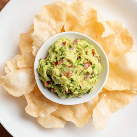 Close-up of crispy pita chips and creamy guacamole, perfect for an easy, flavorful snack combination.