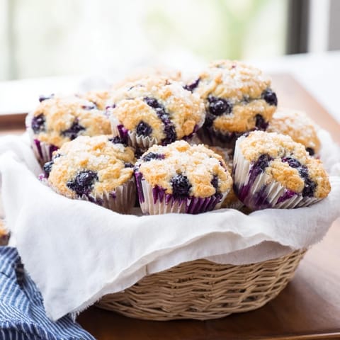 Fluffy mini blueberry muffins with a sprinkle of coarse sugar, perfect for a delightful brunch spread.