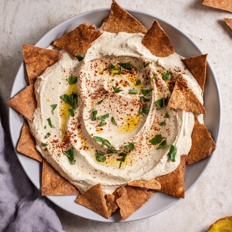 Appetizing photo of the Sahara Dune: smooth hummus mounds, shaped like dunes, ready for dipping with pita chips.