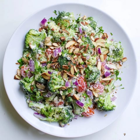 Savory Garlic Parmesan Broccoli Salad garnished with toasted almonds and fresh parsley, perfect for a summer potluck or light lunch.