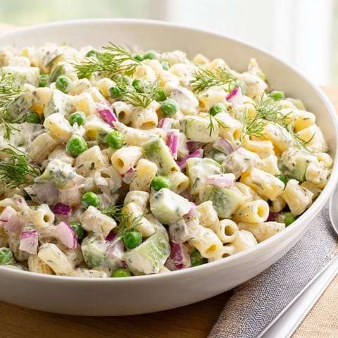 A bowl of Creamy Dill Pickle Pasta Salad featuring tender pasta, crunchy celery, red onion, and a rich mayo-sour cream dressing.