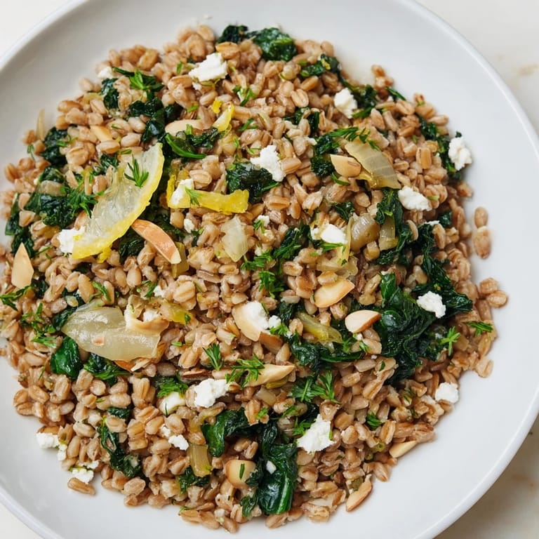 Golden-brown toasted almonds scattered over a delicious Farro & Greens Pilaf with fresh greens.