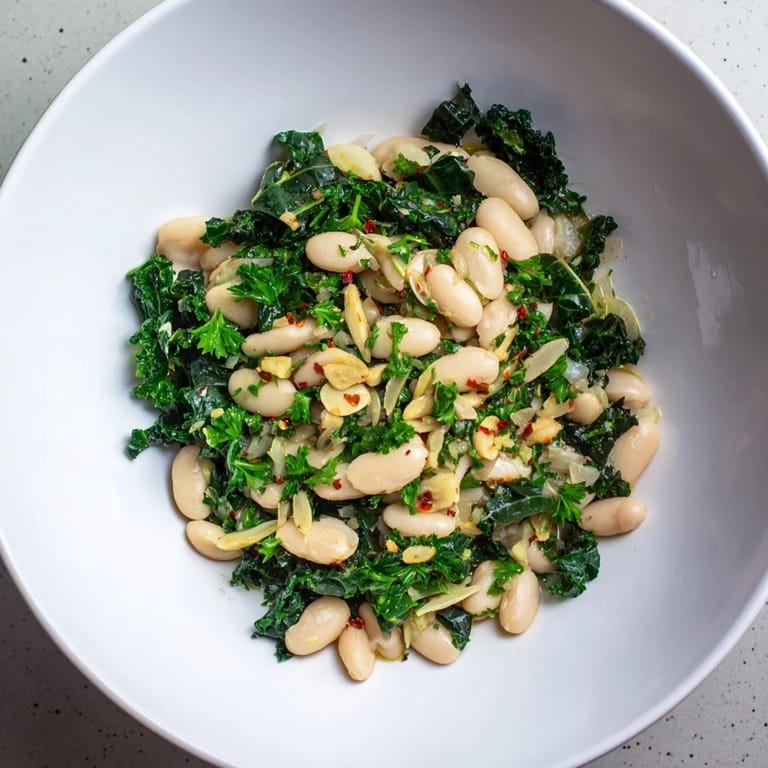 Close-up of hearty Garlicky Beans with Winter Greens, seasoned perfectly with lemon zest and parsley.